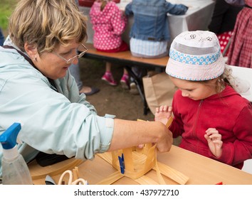 ST. PETERSBURG, RUSSIA - JULY 26, 2015: Unidentified Girl Learns To Weave Bast Basket On A City Fair. Master Class Teaching Children Folk Crafts Weaving A Basket