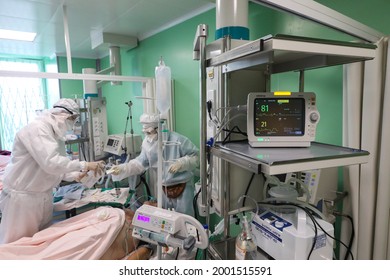 St. Petersburg, Russia - June 27, 2021: Emergency Hospital For Coronavirus. The Doctor Treats Coronavirus In The Intensive Care Unit In An Oxygen Mask And Connect The Resuscitation Wires To The Breath