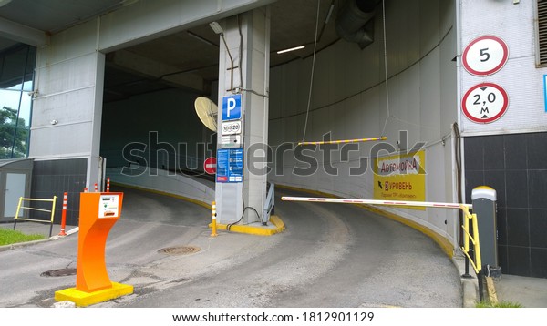 St. Petersburg, Russia - June 30, 2020: Еntry and\
exit to multi-level parking lot of shopping entertainment center.\
Auto wash and quality customer service. Real city life. Convention\
centre. Sign road
