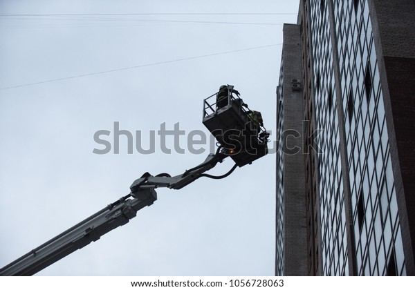 St. Petersburg, Russia - March 28, 2018: A car\
combined fire lift with a cradle between two high-rise buildings.\
Pushed to save people from high floors during an emergency fire\
brigade is at work.