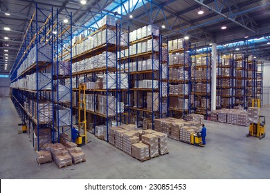 St. Petersburg, Russia - November 21, 2008: Forklift palletiser carrying palletising on the territory of  warehouse. The interior of a large goods warehouse with shelves of pallet rack system storage.