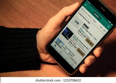St. Petersburg, Russia, November 22 2018. Text London places to stay on site tripadvisor.com. Search for a hotel in London on a mobile site. male hand is holding a smartphone. phone screen closeup
