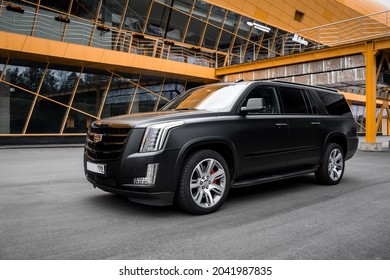 St Petersburg, Russia - September 15, 2021: Cadillac Escalade IV ESV DEPP Limousine Front Three Quarters Urban Landscape View Orange Tone