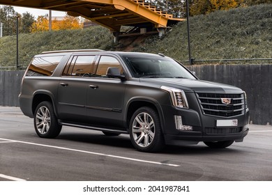 St Petersburg, Russia - September 15, 2021: Cadillac Escalade IV ESV DEPP Limousine Front Three Quarters Urban Landscape View Orange Tone