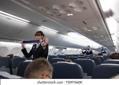 St. Petersburg, Russian Federation - October 16, 2017:  Stewardesses  in the cabin of the Boeing 737-800 passenger airplane instructs passengers on safety measures in the event of an emergency