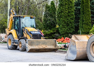 St. Thomas, Ontario, Canada - April 28 2021: CAT 420F2 Backhoe Loader Sits Empty At A Construction Site On A Neighbourhood Street (Locust Avenue) In St. Thomas, Ontario, Canada. 