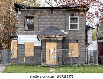 St. Thomas, Ontario, Canada - May 1 2021: Burned and fire damaged house on Queen Street in St. Thomas, Ontario. Cordoned off by metal fence and 'do not enter' and 'no trespassing' signs. Boarded up.