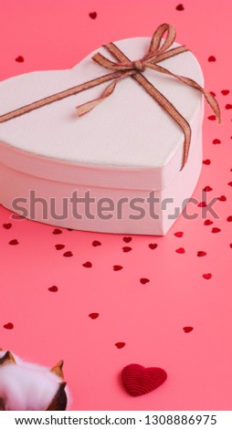 St. Valentine day background. Gift box with gold ribbon and lights on a pink background. Holiday background
