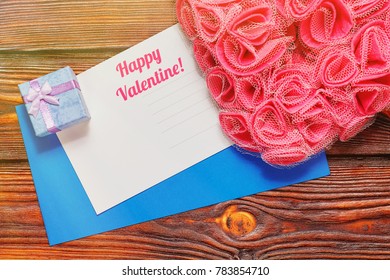 St Valentine Day Greeting Card And An Envelope With Romantic Symbols Nearby - Tiny Gift Box And Heart-shaped Ornament Made Of Man-made Pink Rose Blossoms. Top View Capture, Light Leak Effect.