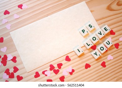 St Valentine's day: a love note for the loved one, with pink and red hearts and letters on a wooden table. Top view with copy space.