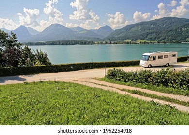St Wolfgang Austria. Motor home camping car parked alongside the lake with mountains in the distance. Light cloud and blue sky. 