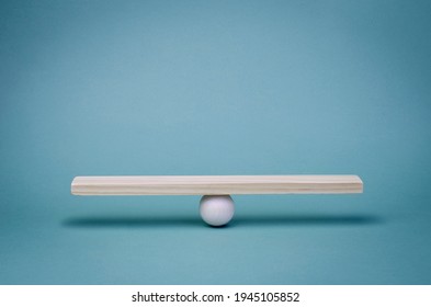 Stability, balance and equality in business partnerships in economic relations. Business finance concept. Wooden scale on a turquoise background.