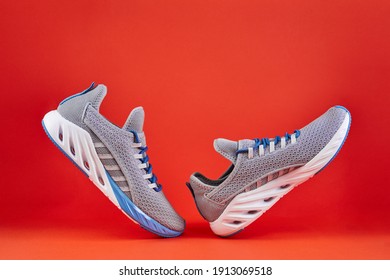 Stability And Cushion Running Shoes. New Unbranded Running Sneaker Or Trainer On Orange Background. Men's Sport Footwear. Pair Of Sport Shoes.