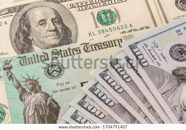Stack of 100 dollar bills with illustrative\
coronavirus stimulus payment check to show the virus stimulus\
payment to Americans