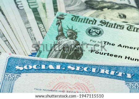 Stack of 100 dollar bills with US Treasury illustrative check to illustrate American Rescue Plan Act of 2021 payment with social security card for retirees