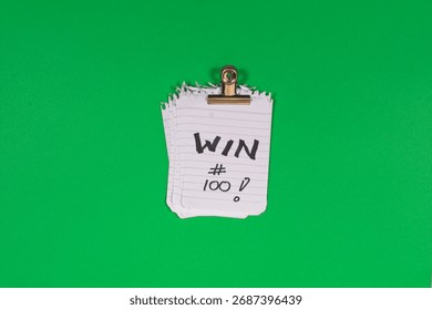 A stack of 100 paper win tickets on a green background as a symbol of winning, gains, growth mindset and the psychology of daily goalsetting.