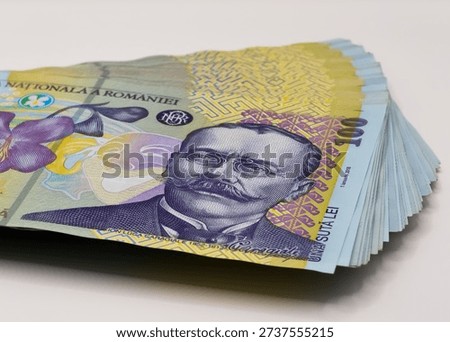 A stack of 100 Romanian Leu banknotes (RON) featuring writer Ion Luca Caragiale. The polymer bills are fanned out against a plain white background, showing the National Bank of Romania logo.