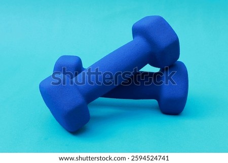 Stack of 2 blue barbells on a blue background