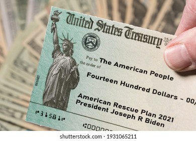 Stack Of 20 Dollar Bills With US Treasury Illustrative Check To Illustrate American Rescue Plan Act Of 2021 Payment On Cash Background