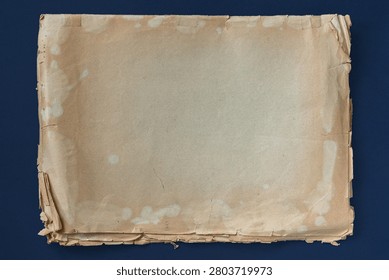 Stack of aged papers with torn edges isolated on dark background, stains, folds, archive document surface, old stained paper backdrop. Natural vintage paper background, history, archive, copy space