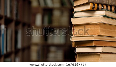 The stack ancient books on a library background