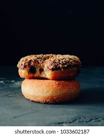 Stack of assorted donuts on a black background.
