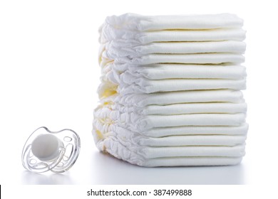 Stack of baby disposable diapers and Pacifier over white background