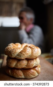 A stack of bagels and an old man in blurred background