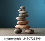 Stack of Balanced Pebbles on a Light Blue Colored Background, zen pebbles, relax, massage, meditation, studio photography