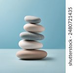 Stack of Balanced Pebbles on a Light Blue Colored Background, zen pebbles, relax, massage, meditation, studio photography