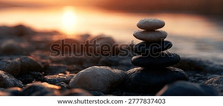 A stack of balanced stones on a pebble beach with a warm sunset in the background, symbolizing peace and tranquility.