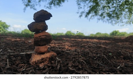 Stack of balancing rocks on the ground in a natural outdoor environment