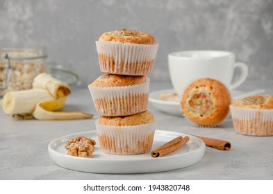 Stack of Banana muffins with oatmeal, walnuts and cinnamon on a white plate on gray concrete background. Healthy dessert - Powered by Shutterstock