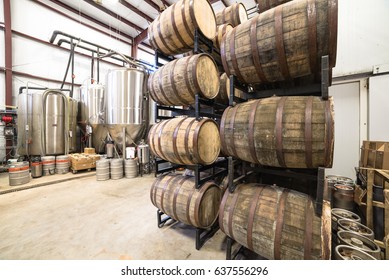 Stack of barrels in cellar with stainless steel brewing equipments in a modern microbrewery in America. - Powered by Shutterstock