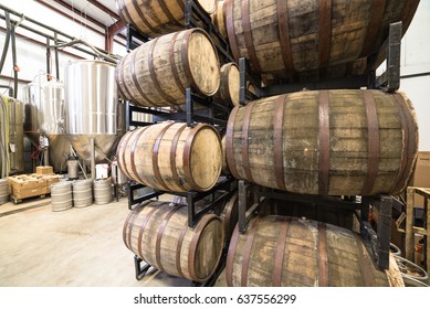 Stack of barrels in cellar with stainless steel brewing equipments in a modern microbrewery in America. - Powered by Shutterstock