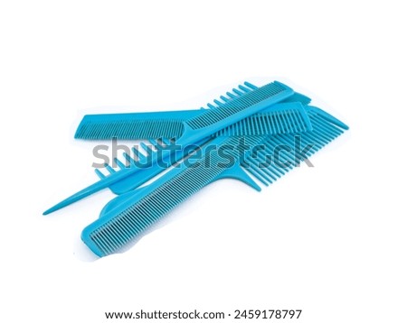 a stack of beautiful blue combs with various curved models, for a make-up artist or barber, isolated on a white background.