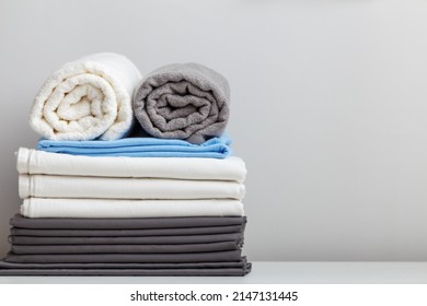 A Stack Of Bed Linen, Sheets And Towels On The Table. Copy Space