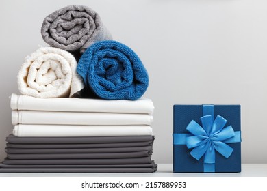 Stack of bed linen sheets towels gift box on the table
