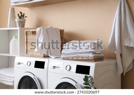Stack of bed sheets on washing machine in laundry room