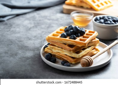 Stack of belgian waffles with blueberry and honey for breakfast. Delicious homemade pastry. Copy space. - Powered by Shutterstock