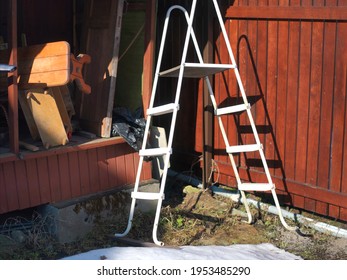 Stack Of Benches And Ladder In A Messy Yard, Sunny Day Shot