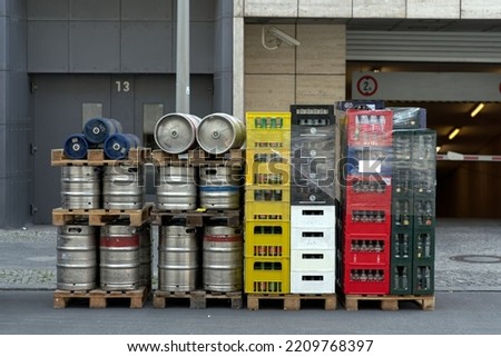 Stack of a beverage delivery in Berlin with beverage crates and metal barrels at the back of a restaurant.	