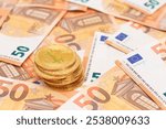 A Stack of Bitcoin Coins on the 50 Euro Banknotes. Euro Currency and Crypto Currency. Orange Paper Money. A Lot of Fifty-Euro Bills. Finances, Cash, Anonymous Payments and Money Saving Concept