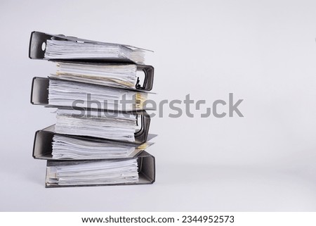 stack of black file folders full of documents against white background, space for your text