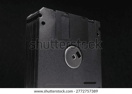 Stack of black floppy disks used for magnetic data storage in retro computers