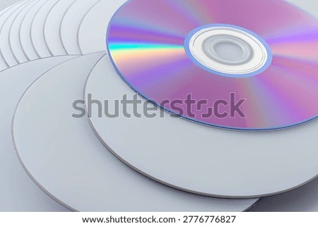 Stack of blank CDs and DVDs with iridescent rainbow surface showing data storage media collection. Perfect for technology, data backup, and archival concepts.