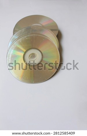 Stack of blank DVDs and CDs with scratch colorful disc on top, isolated on white background. Perfect for technology, data storage, media, and archival concepts in professional and commercial designs.