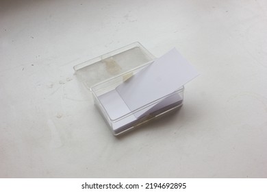 The Stack Of Blank Name Card In The Transparent Dirty Box, Is Isolated On White Background, For Corporate Identity Branding Design Mockup Or Presentation.