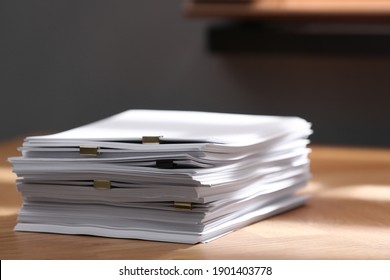Stack of blank paper with binder clips on wooden table indoors - Shutterstock ID 1901403778