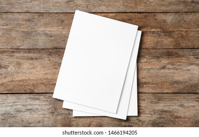 Stack Of Blank Paper Sheets For Brochure On Wooden Background, Top View. Mock Up